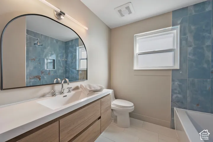 Expansive floating vanity with an integrated rectangular sink, wood-finish cabinetry, and chrome fixtures