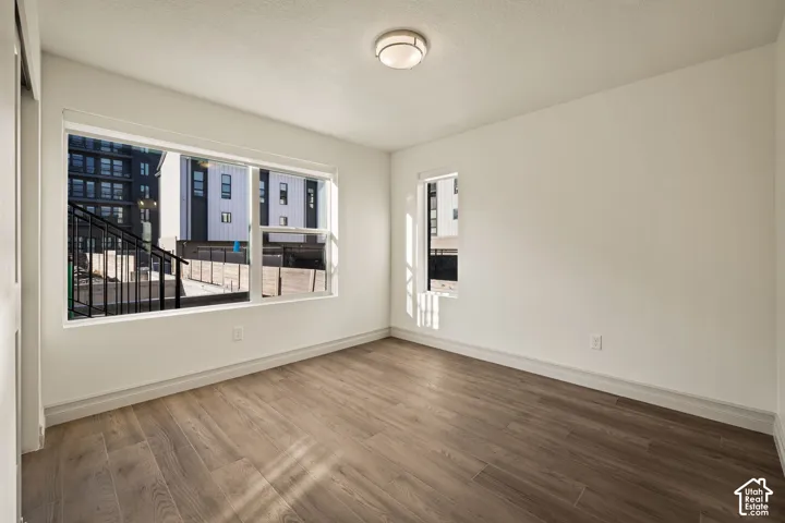 Wood-finish flooring throughout, bright white walls, and a large picture window