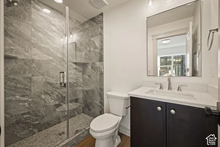 Glass-enclosed shower with large format tile surround and integrated shelving