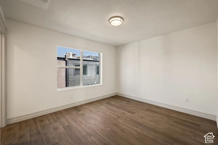 Recessed lighting, wood-finish flooring, white walls, and a large window