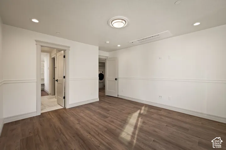 Wood-finish flooring, white walls with wainscoting, recessed lighting, and a flush-mount ceiling light