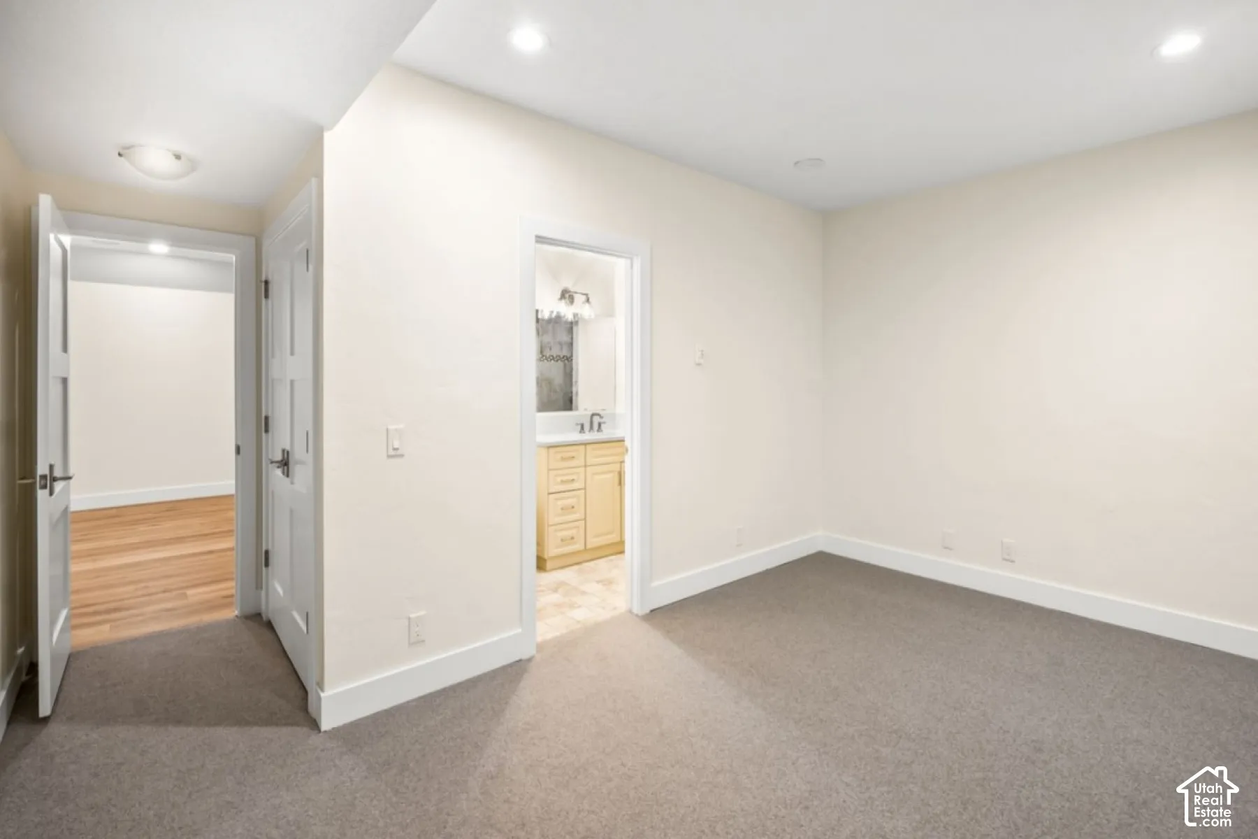Neutral wall finishes, recessed lighting, and grey carpeting