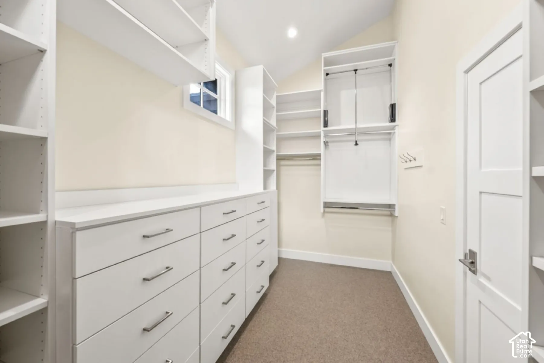 Built-in white cabinetry with ample drawers, integrated shelving, and hanging rods
