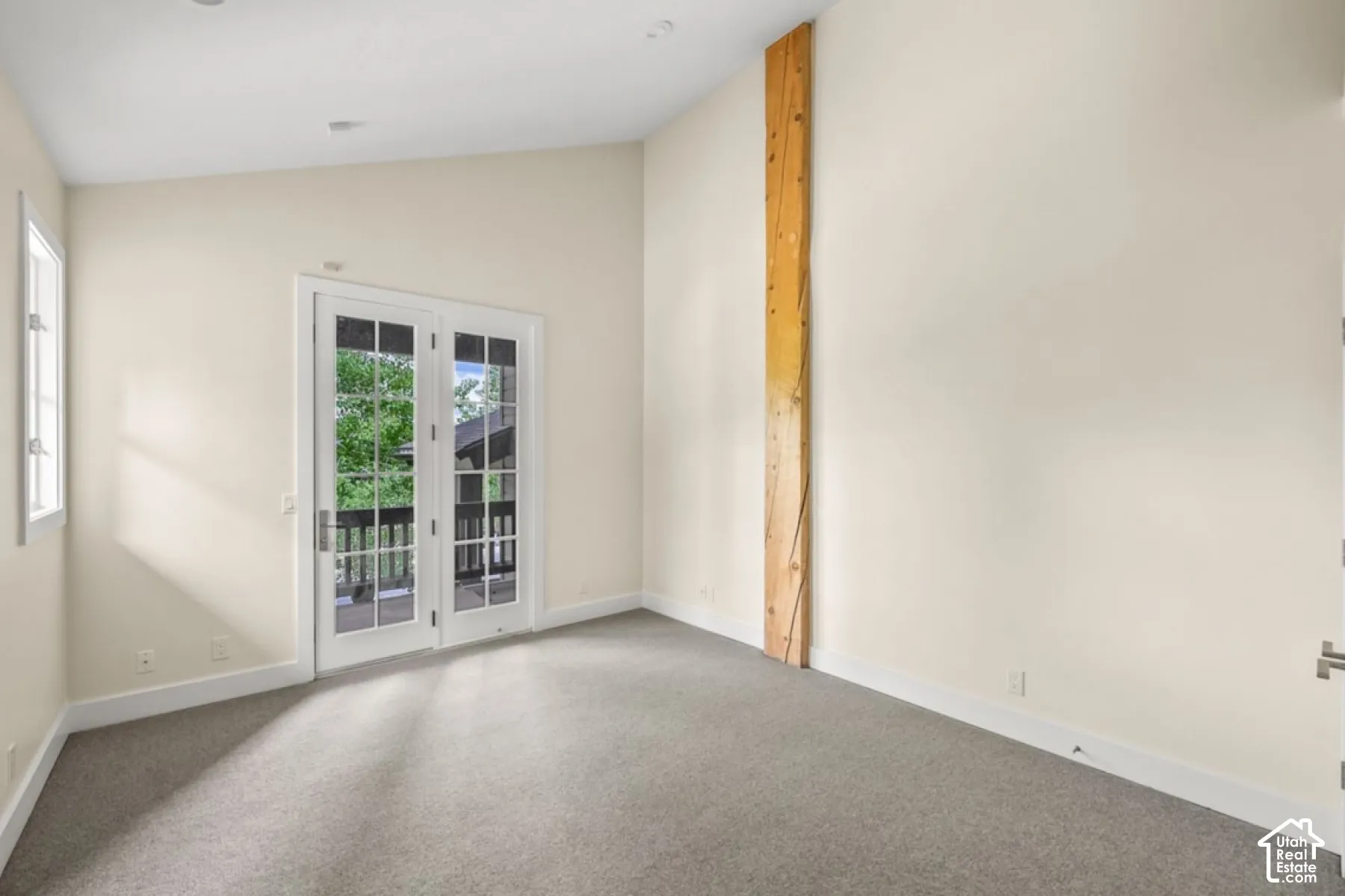 Room featuring a vaulted ceiling, recessed lighting, and a prominent wood beam
