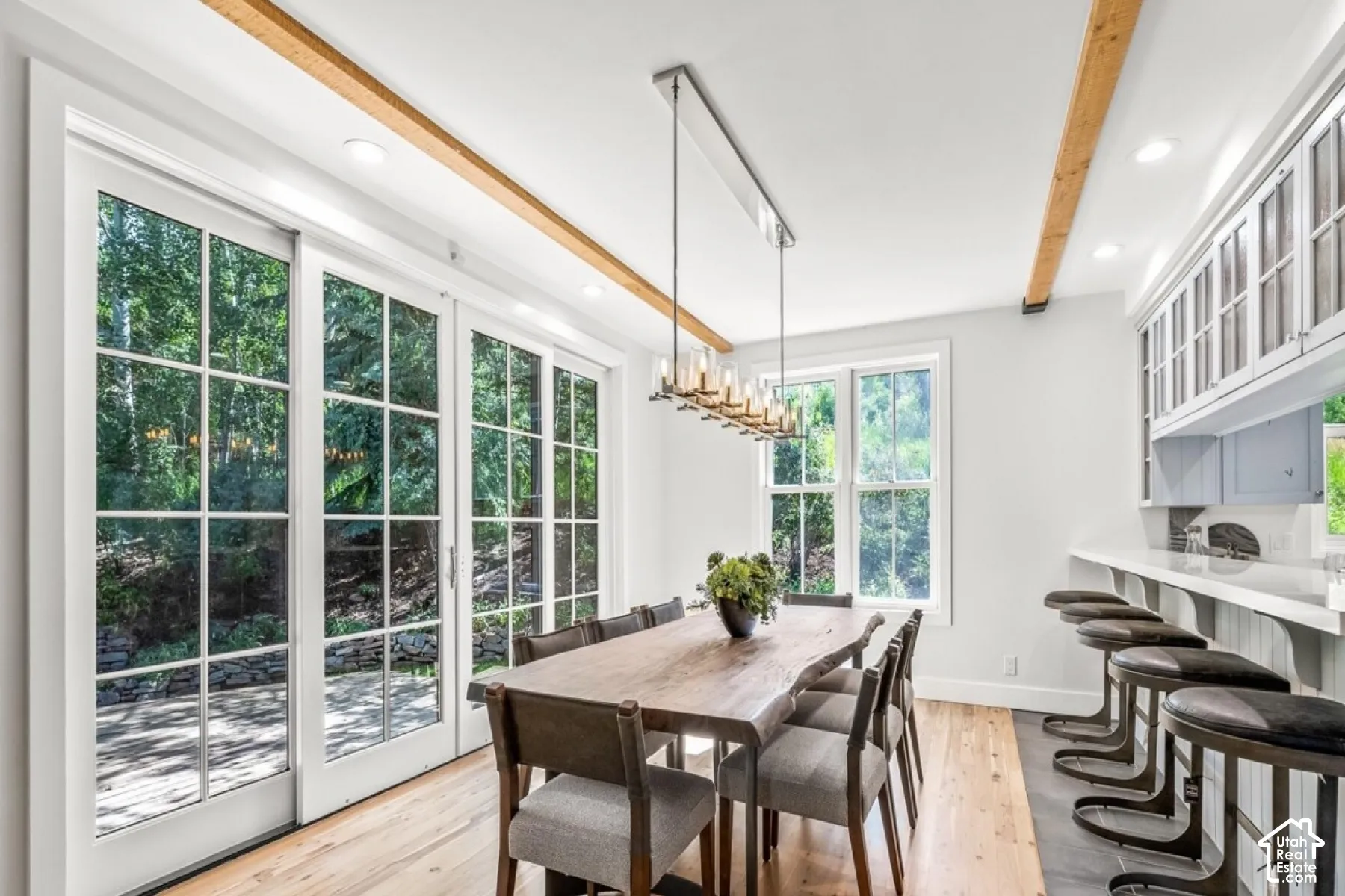 Hardwood flooring, exposed ceiling beams, recessed lighting, and a built-in bar with a solid surface countertop