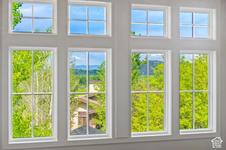 Expansive window arrangement with multiple panes, white trim, and a serene green landscape