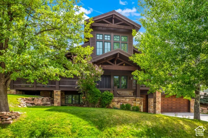 Craftsman-style exterior with wood siding, stone accents, and a prominent front balcony
