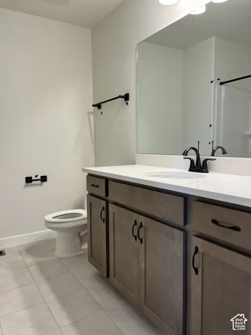 Wood-finish vanity with white countertop, undermount sink, and matte black faucet