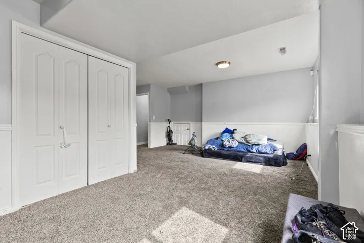 Wall-to-wall carpeting, paneled closet doors, and wainscoting details create a refined interior