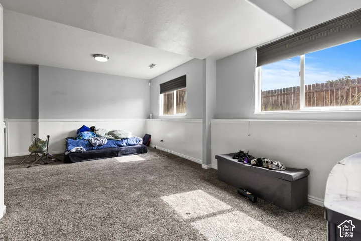 Carpeted room with multiple windows, recessed lighting, and a chair rail