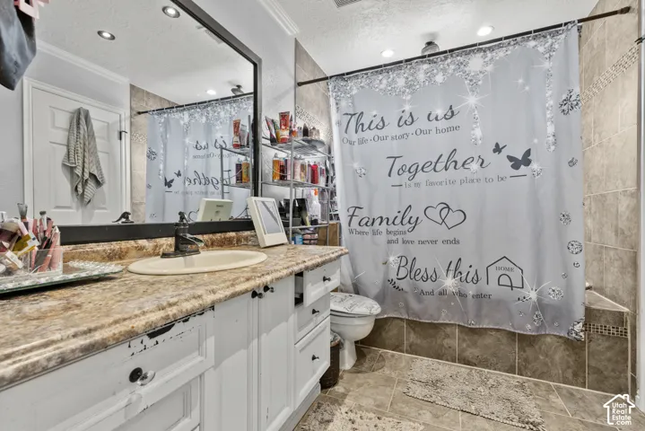 Wood-finish vanity with an integrated sink, framed mirror, recessed lighting, and tile flooring