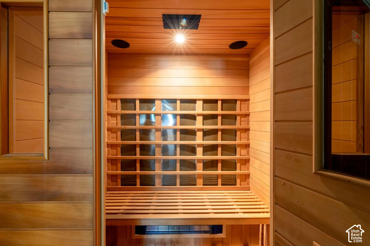 Wood-paneled interior featuring a slatted bench, built-in lighting, and an integrated heat source