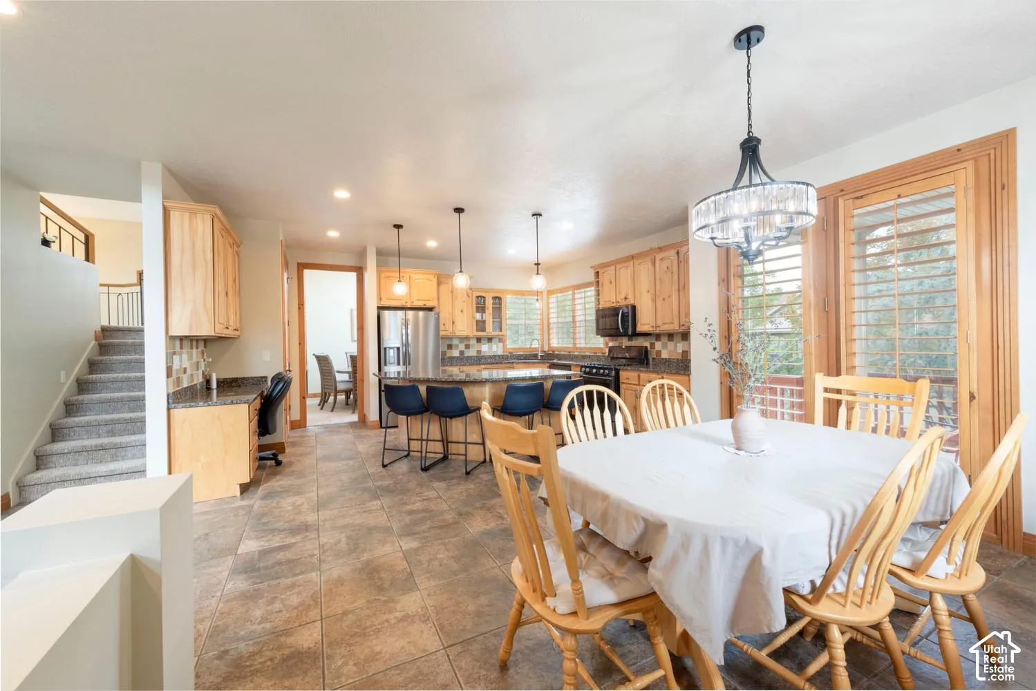 Tile flooring with a decorative chandelier, recessed lighting, and natural wood cabinetry