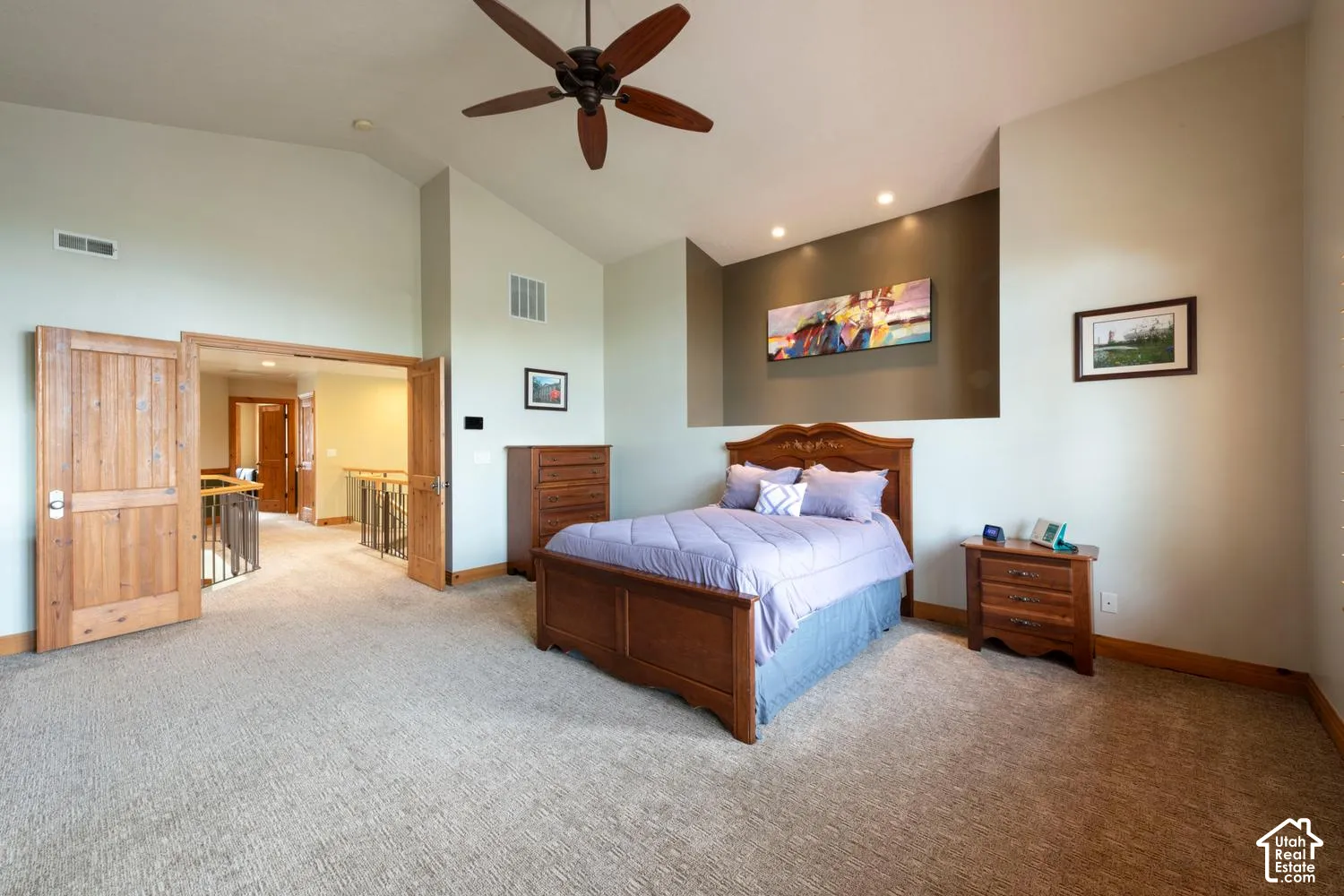 Vaulted ceiling, ceiling fan, recessed lighting, textured carpet flooring, and solid wood double doors