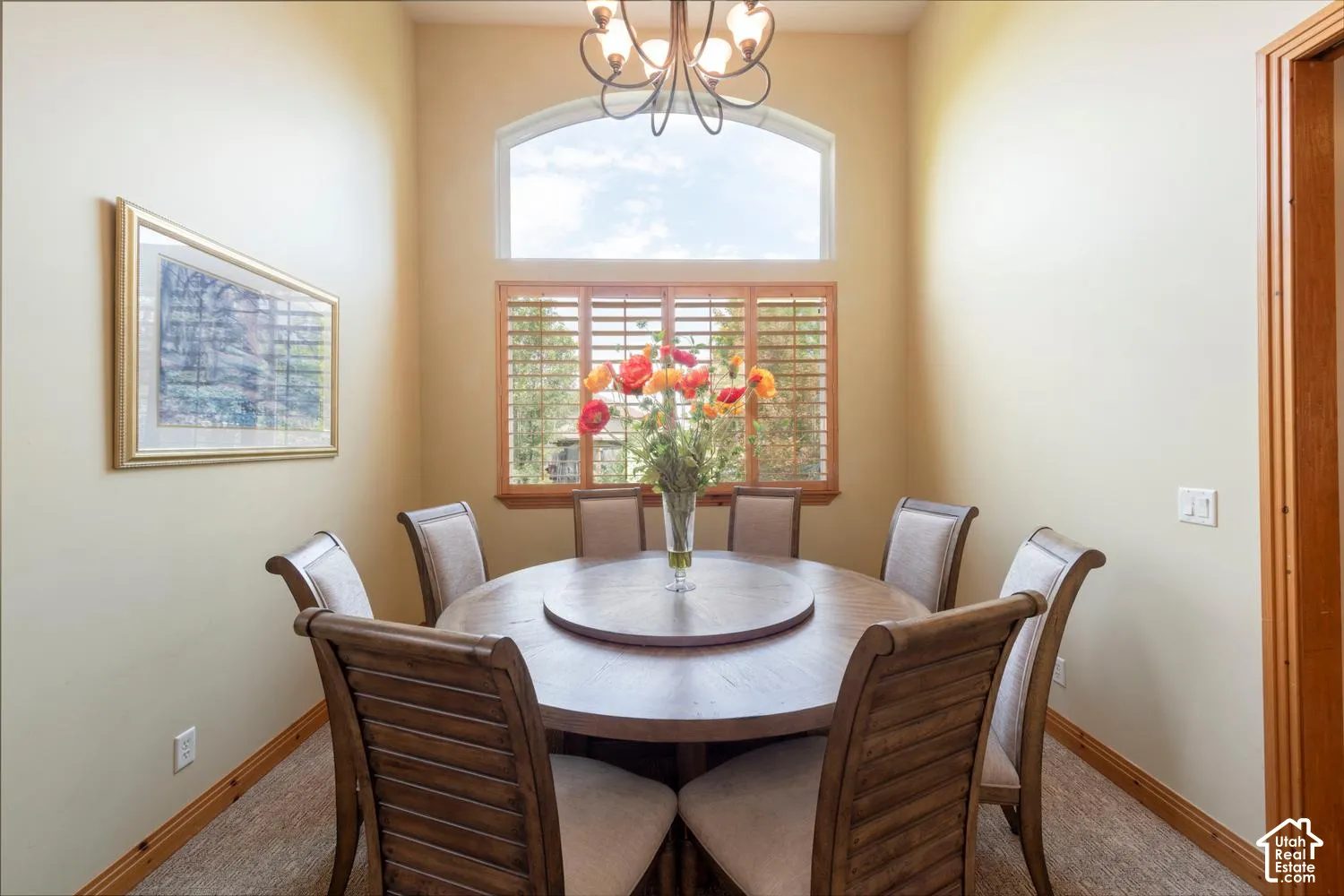 Arched window with plantation shutters, vaulted ceilings, and wood-trim accents