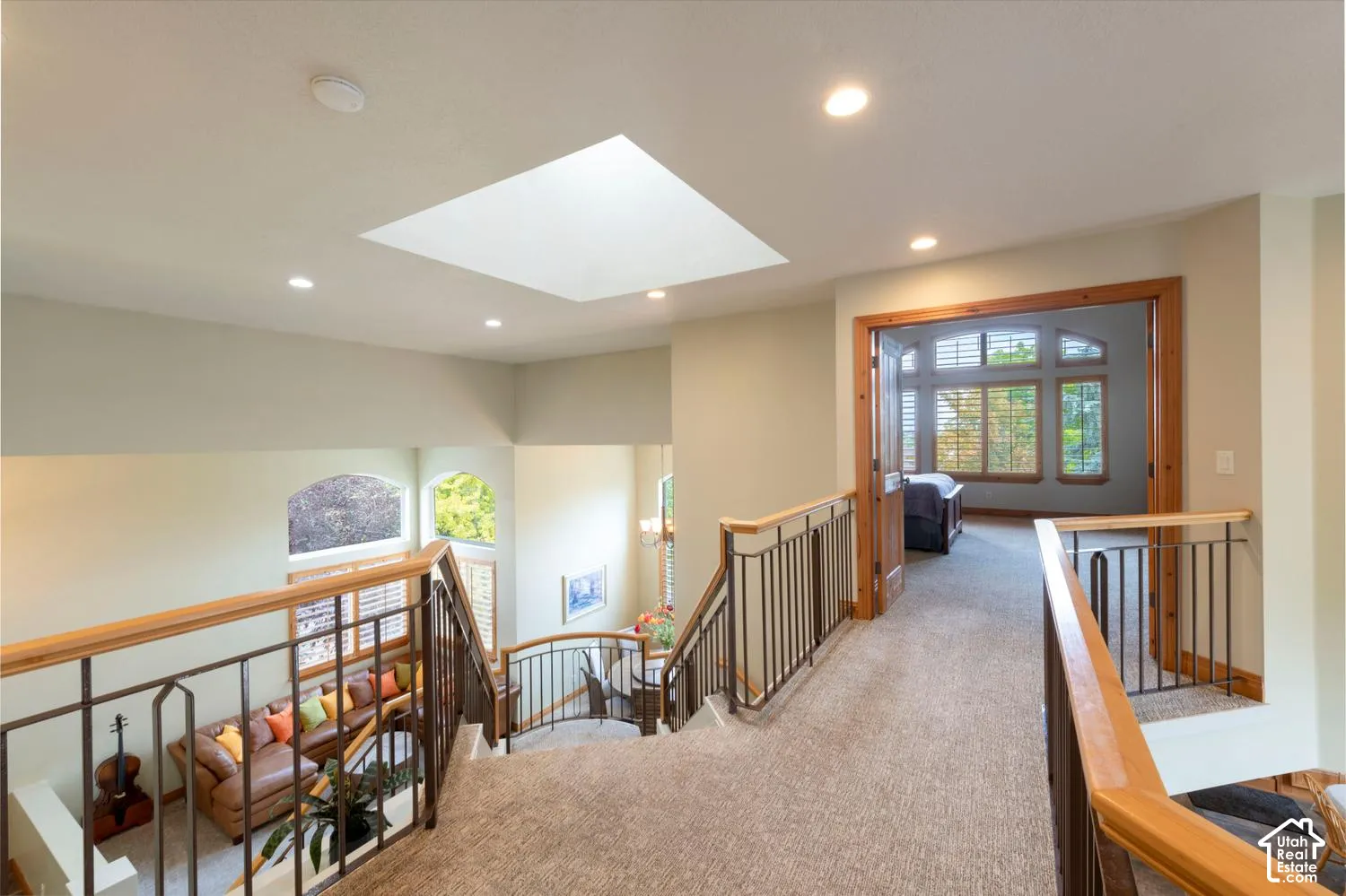 Carpeted landing with recessed lighting, skylight, and wood-framed doorways