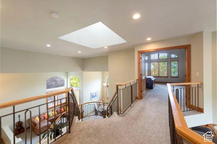 Carpeted landing with recessed lighting, skylight, and wood-framed doorways