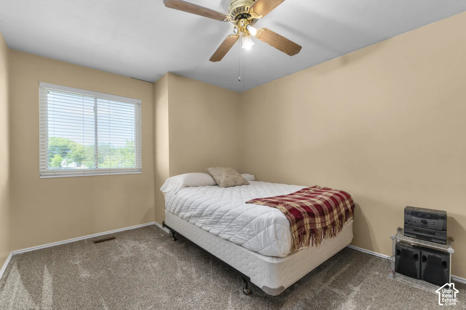 Wall-to-wall carpeting, window with blinds, ceiling fan with light, and neutral wall paint