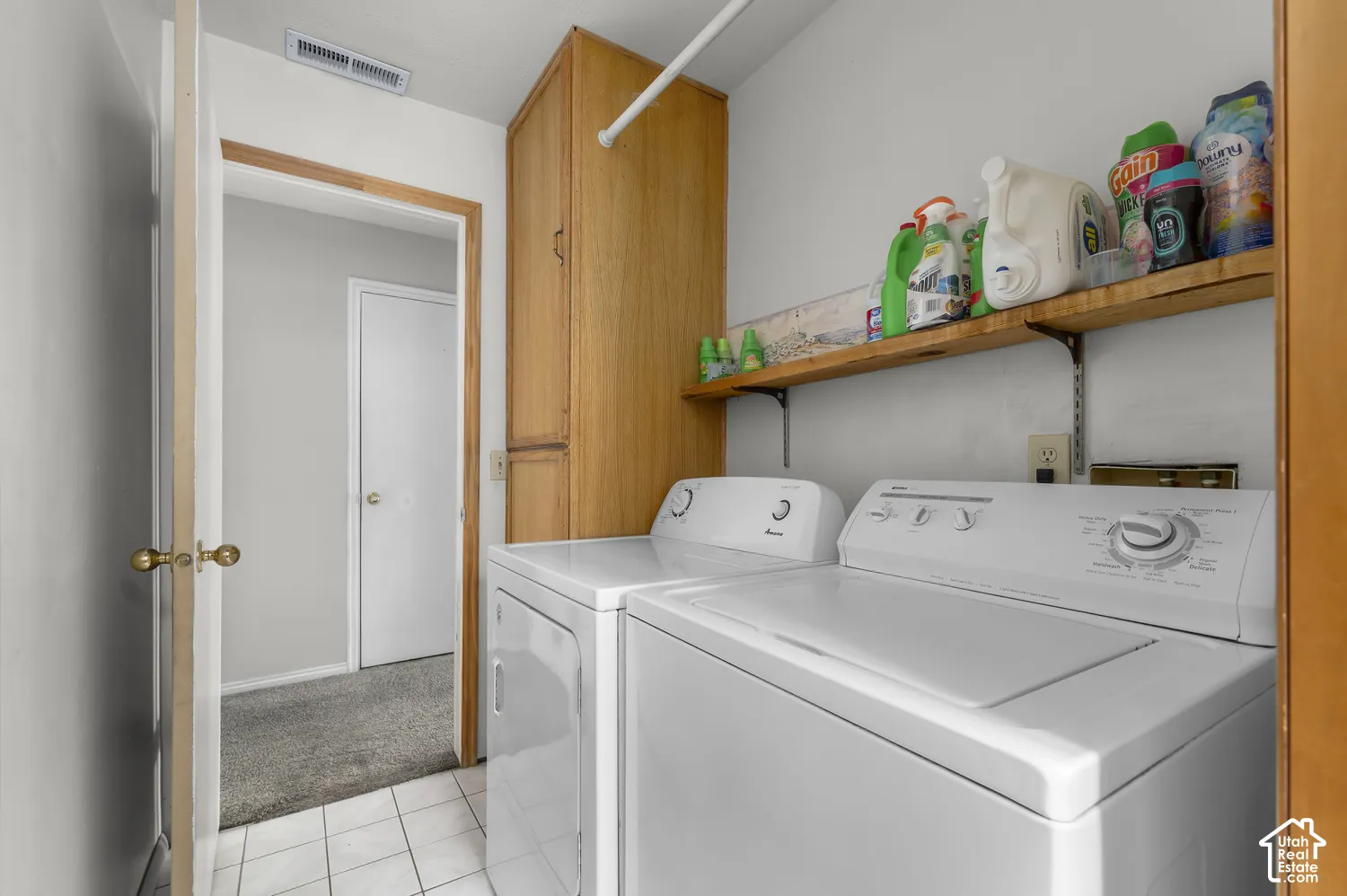 Ceramic tile flooring, built-in wooden shelving, and wood-finish cabinetry