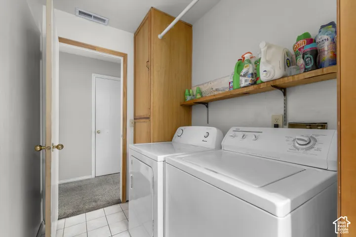 Ceramic tile flooring, built-in wooden shelving, and wood-finish cabinetry