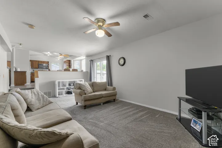 Carpeted living area with a ceiling fan light fixture