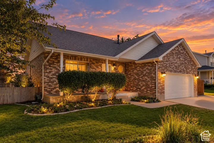 Brick facade, attached garage, gabled roofline, front porch, landscape lighting
