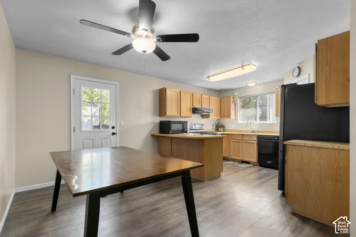 Kitchen featuring wood-finish flooring, light-toned cabinetry, and black appliances