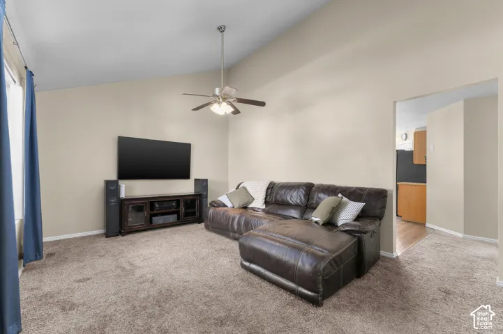 Vaulted ceiling, carpeted flooring, and a ceiling fan