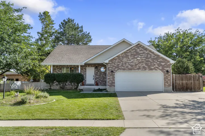 Brick and siding exterior with an attached garage, covered entry, and concrete driveway