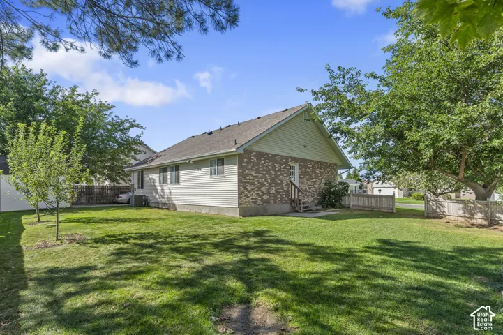 Expansive green lawn with mature trees and a fenced perimeter