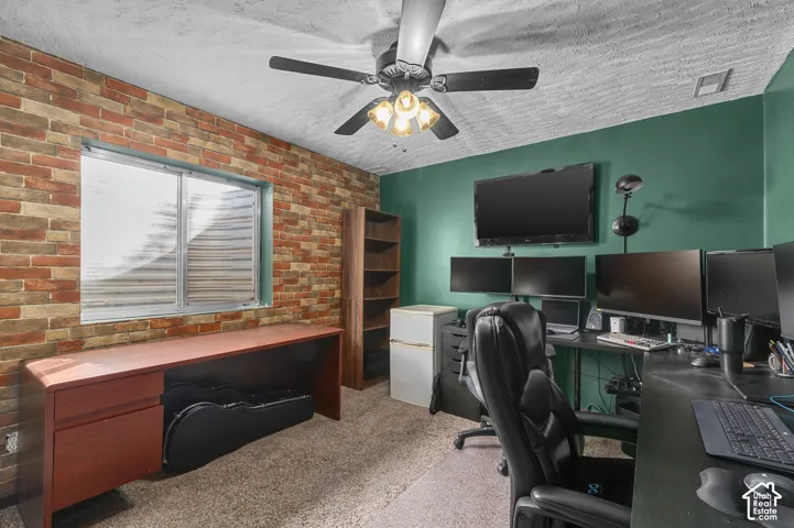 Textured brick-look accent wall, painted green walls, and carpet flooring