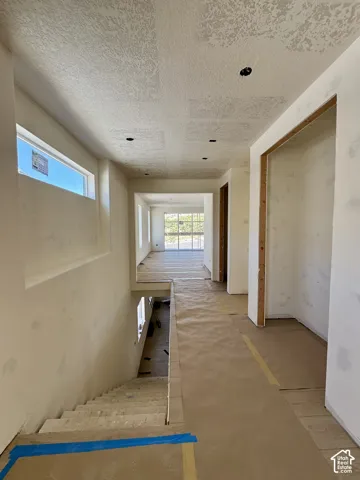 Recessed ceiling lighting, horizontal window, open doorways, and an interior staircase