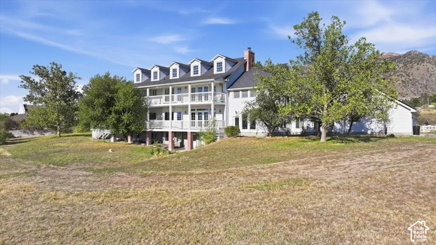 Multi-level exterior with multiple balconies, dormer windows, and a prominent chimney