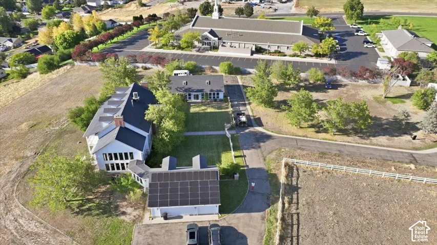White-sided residence featuring a dark roof, multiple windows, and solar panels