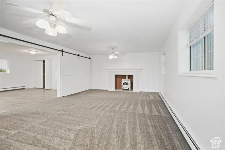 Carpeted flooring, white walls, and a fireplace with a white mantel