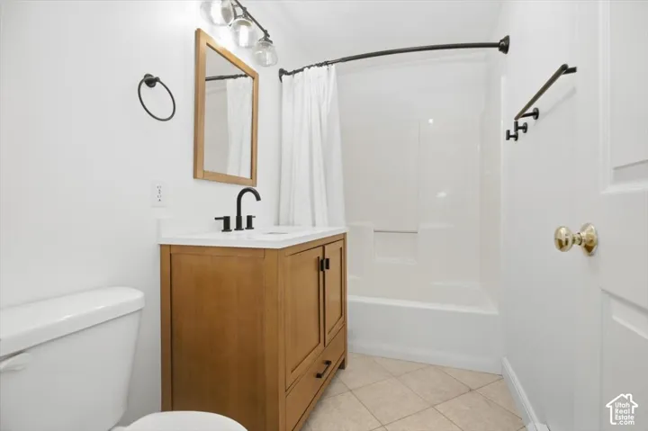 Wood-finish vanity with a white countertop and matte black faucet