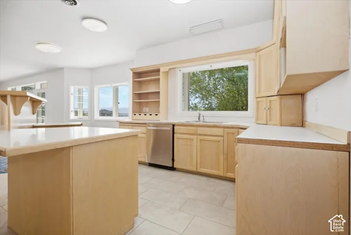 Light wood cabinetry with integrated shelving and stainless steel appliances