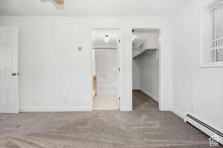 Carpeted flooring, white walls, and a window with blinds