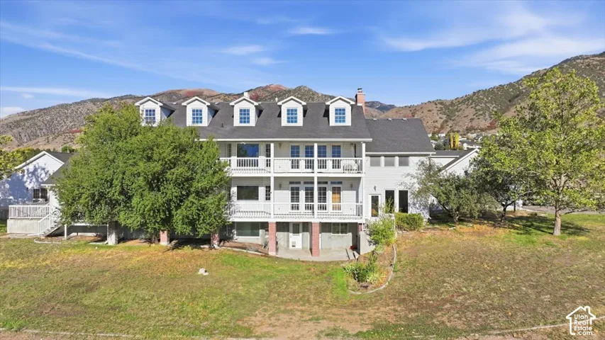 Multi-level exterior with multiple balconies, dormer windows, and a prominent chimney feature