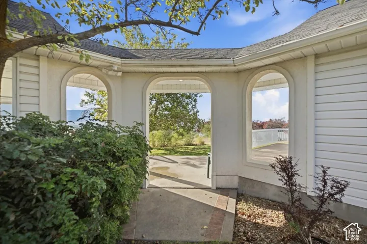 Arched entryways with a concrete pathway and white siding