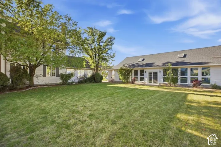 Expansive green lawn with mature trees and established landscaping