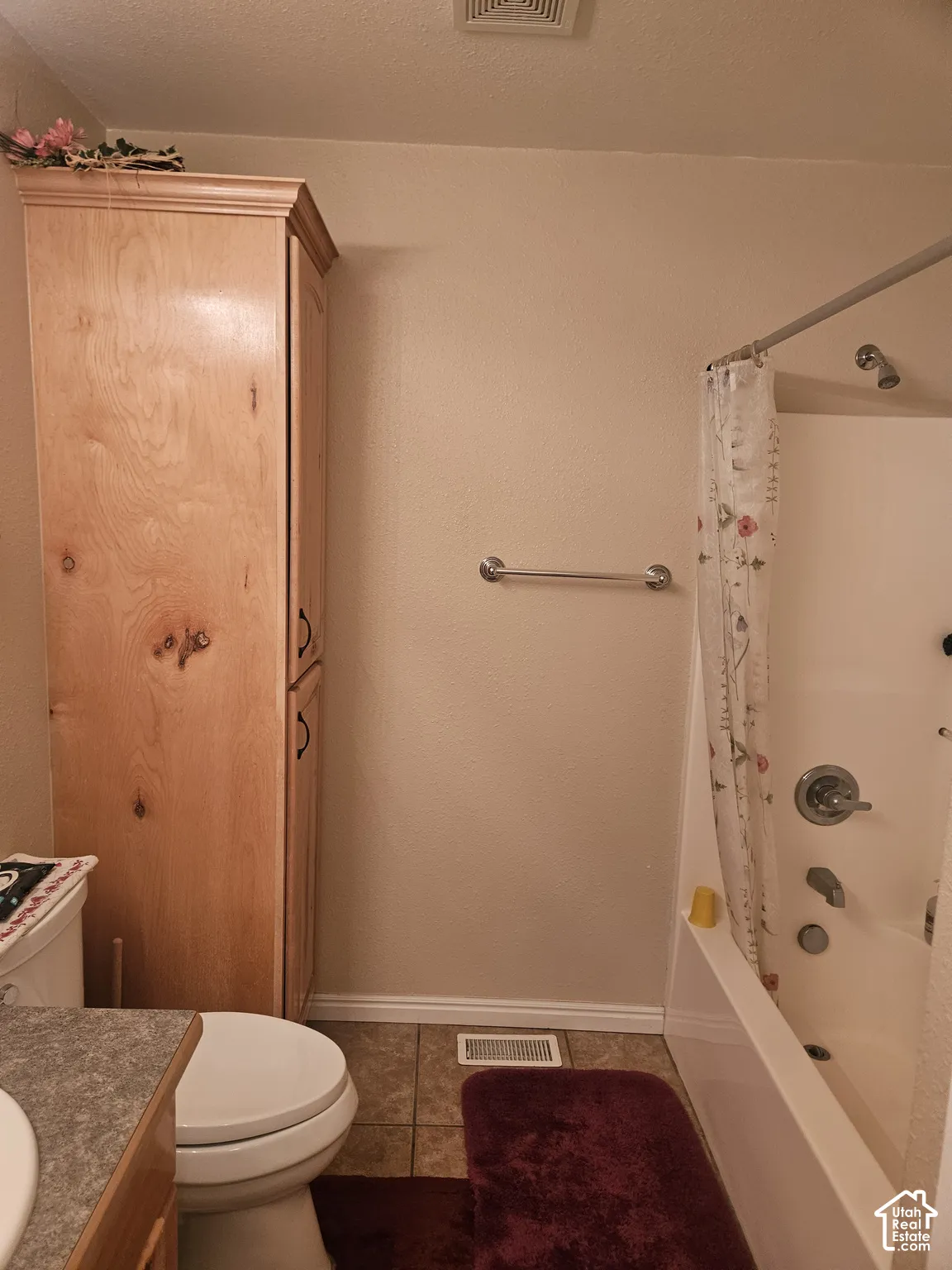 Built-in wood-finish cabinetry, tile flooring, and a shower-over-tub combination