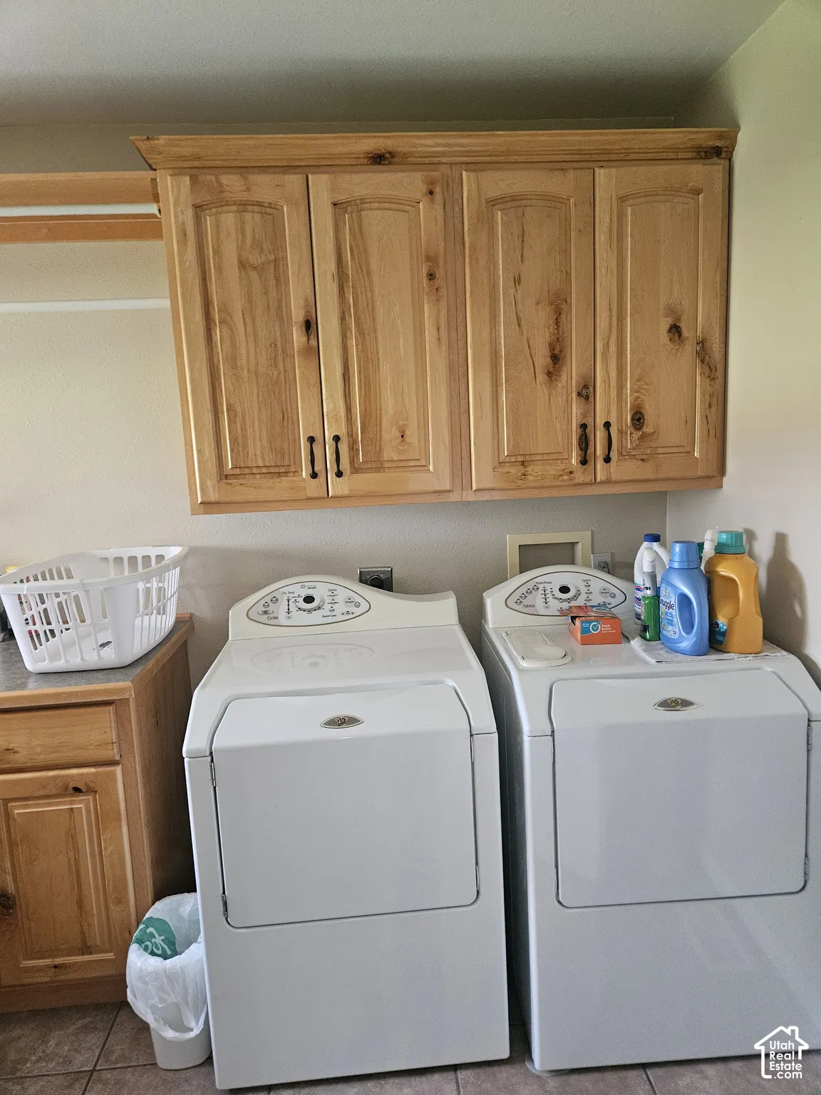 Light wood-finish cabinetry, built-in countertop, and tiled flooring