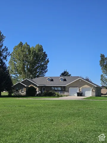 Stucco exterior with stone accenting, a covered front porch, and a two-car garage