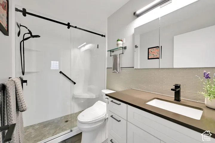 Glass-enclosed shower with a built-in bench, black-finish fixtures