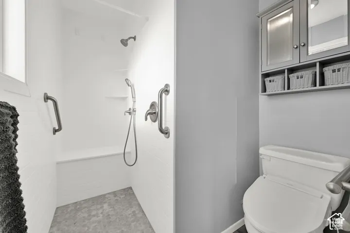 Primary bath with walk-in shower, a built-in bench, dual shower heads, and an integrated grab bar