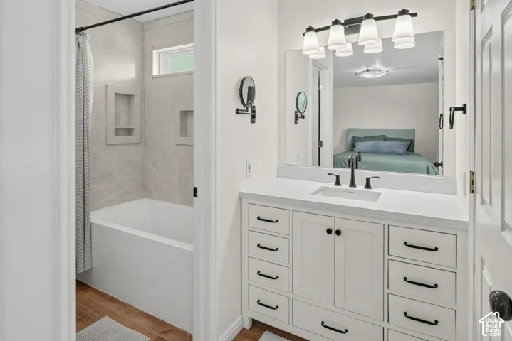 White vanity with a light-colored countertop, undermount sink, and matte black faucet