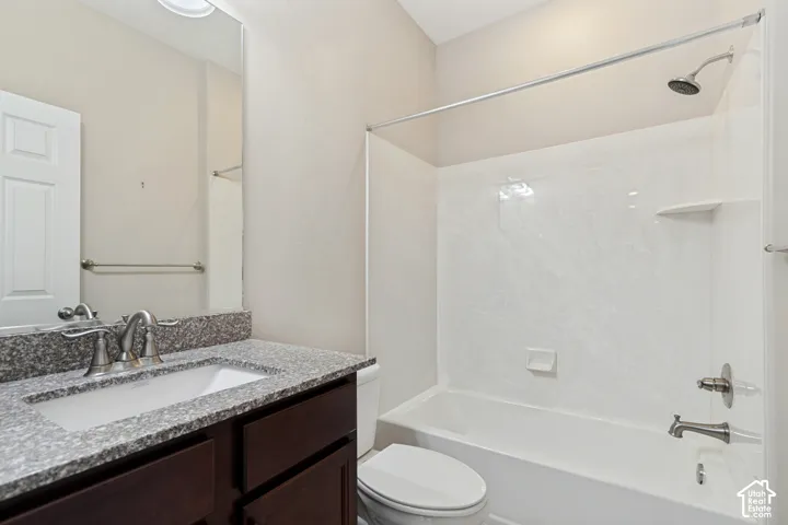 Vanity with a granite countertop, integrated sink, and brushed nickel faucet