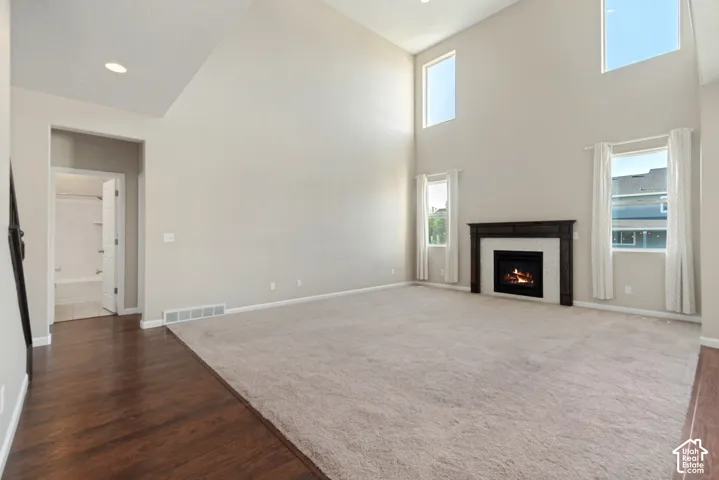 Vaulted ceilings, recessed lighting, and a dark wood-finish mantel over a fireplace