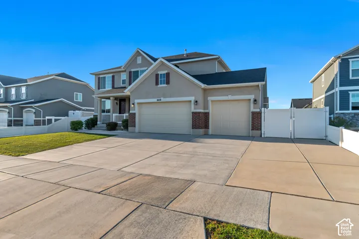 Two-story residence featuring a two-car garage, front porch, and a concrete driveway